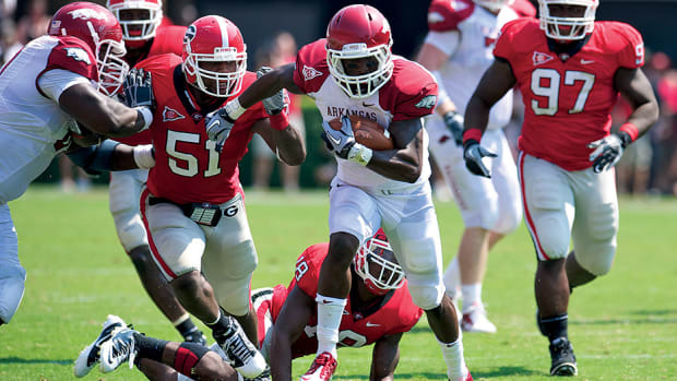 Arkansas Razorbacks wide receiver Joe Adams breaks tackles by Georgia Bulldogs safety Bacarri Rambo and linebacker Akeem Dent in the third quarter at Sanford Stadium. Arkansas defeated Georgia 31-24.